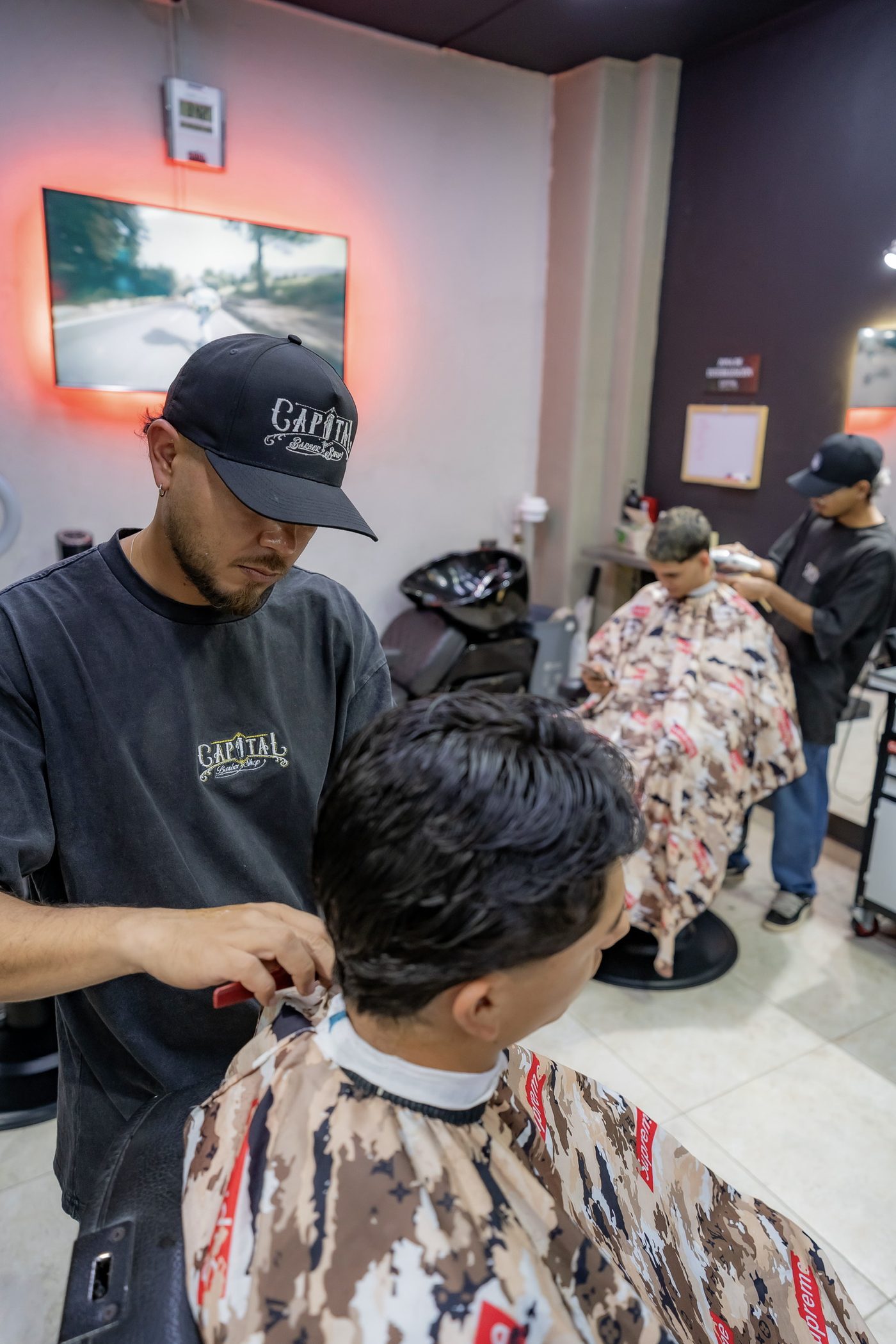Barberos de Capital Barber Shop atendiendo clientes